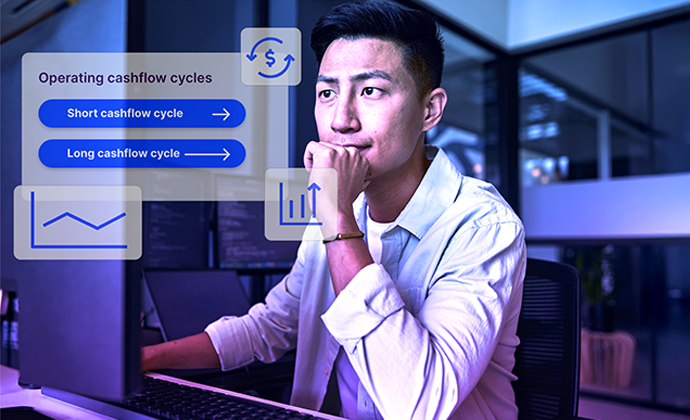 A young broker sits at a desk, looking at a computer. A blue-tinted overlay features 'Operating cashflow cycles' with buttons for 'Short cashflow cycle' and 'Long cashflow cycle,' along with icons of a dollar sign and a bar chart.
